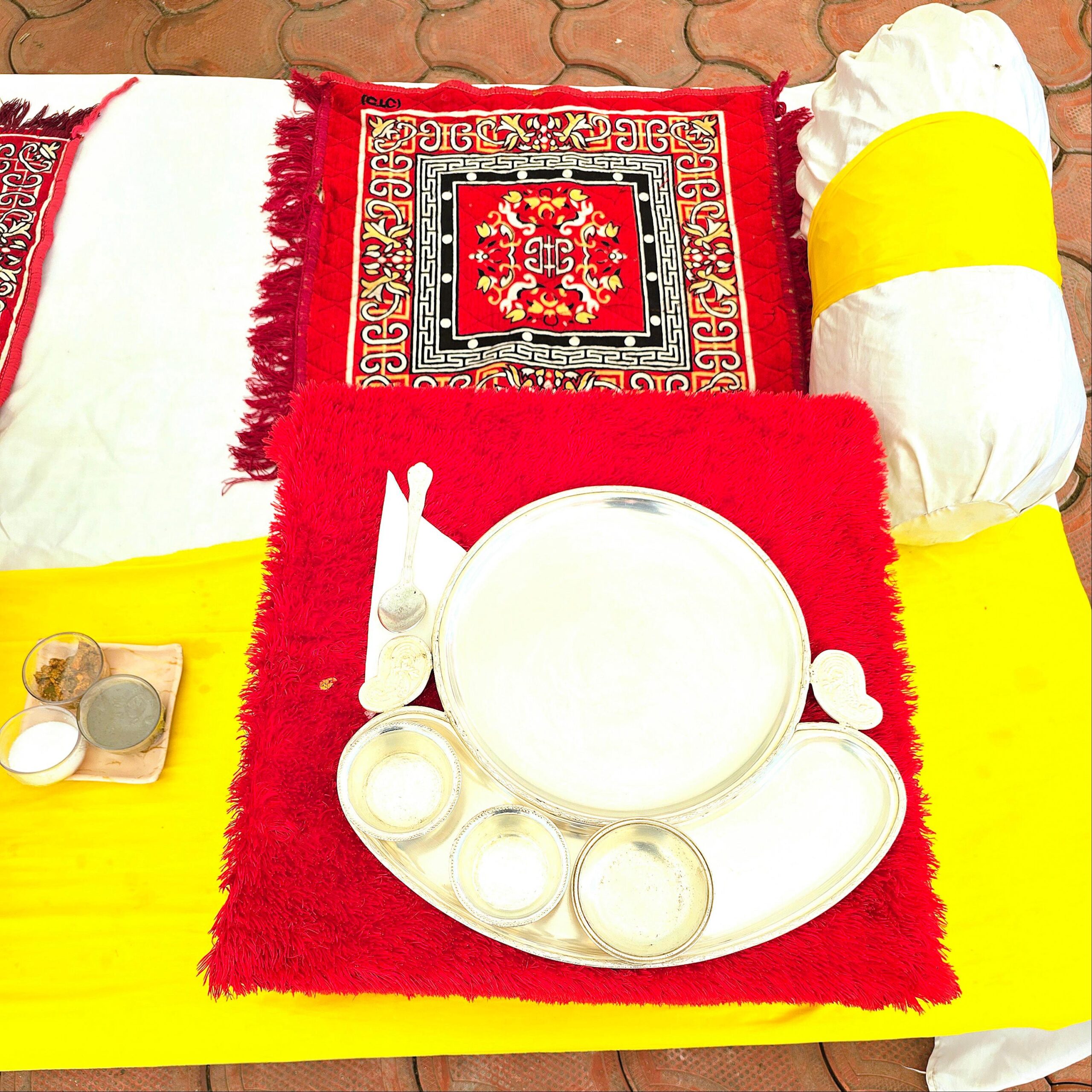 Traditional Wedding Dining Setup in Bhopal Traditional wedding dining setup with floral carpet, silver thali service and royal takhat seating at Utsav Marriage Garden, Bhopal.